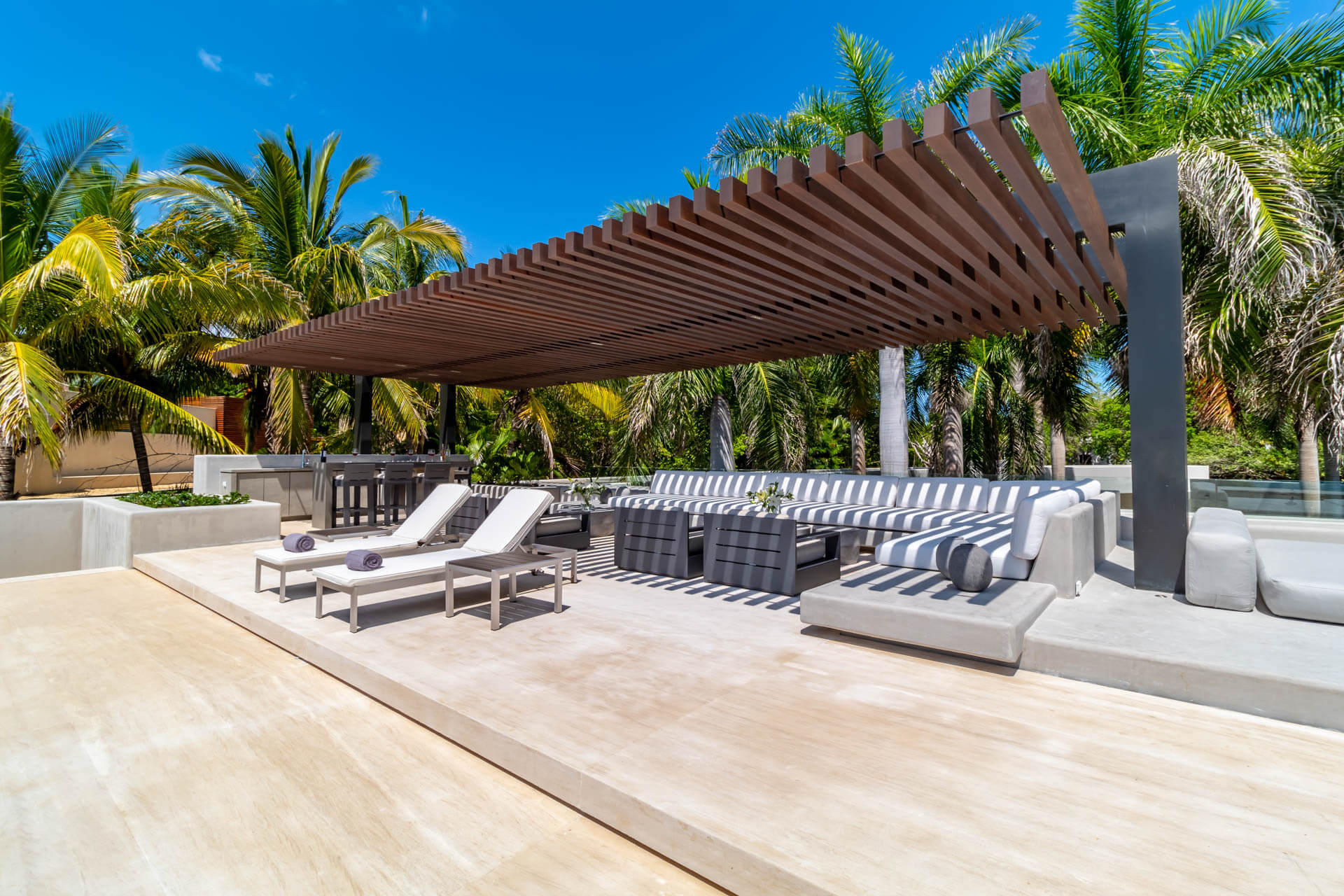 Pool terrace pergola with striped sectional and lounge chairs, Estate Afrique, Ranchos Estates, Punta Mita.