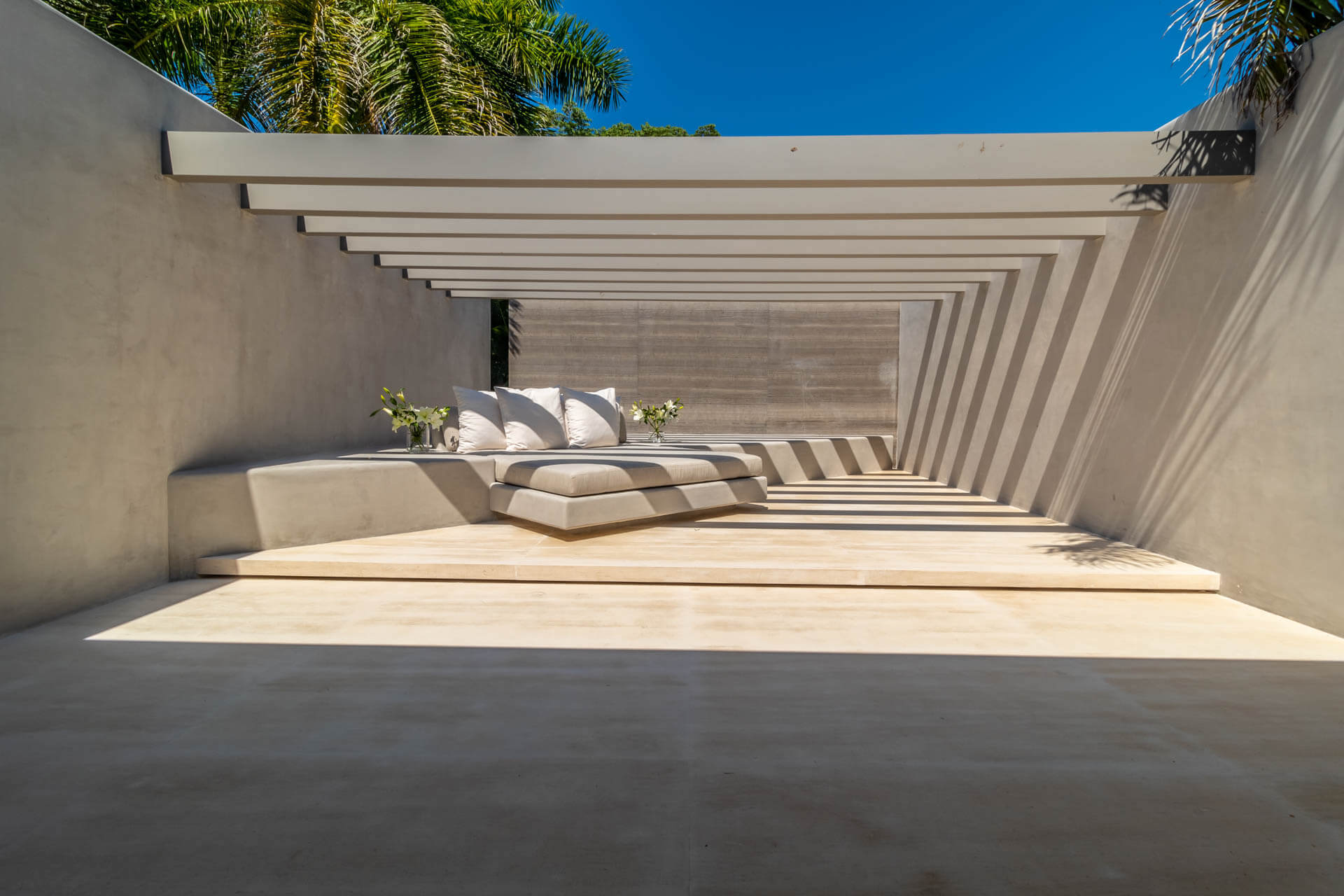 Concrete louvered spa alcove with built-in day-bed, white cushions, and repeating shadow-stripe ceiling detail, Estate Afrique, Ranchos Estates, Punta Mita.