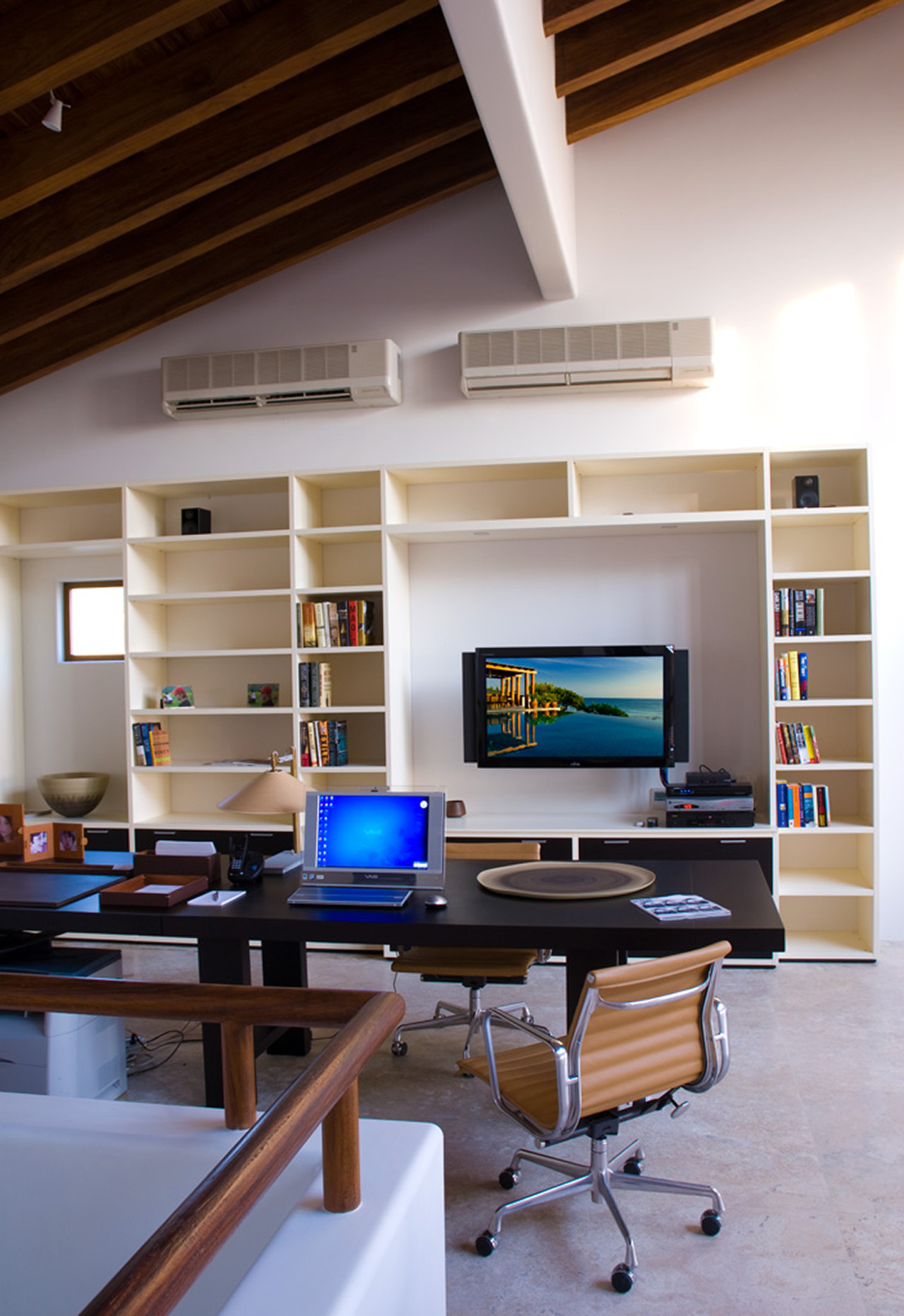Media room desk and office chair beneath exposed beam ceiling with built-in shelving and mounted flat-screen, Estate Jaguar, Ranchos Estates, Punta Mita.