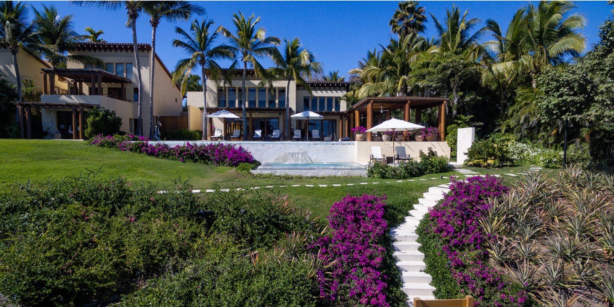 Manicured arrival lawn with bougainvillea-lined steps leading up to the pool terrace and main pavilion, Estate Jaguar, Ranchos Estates, Punta Mita.