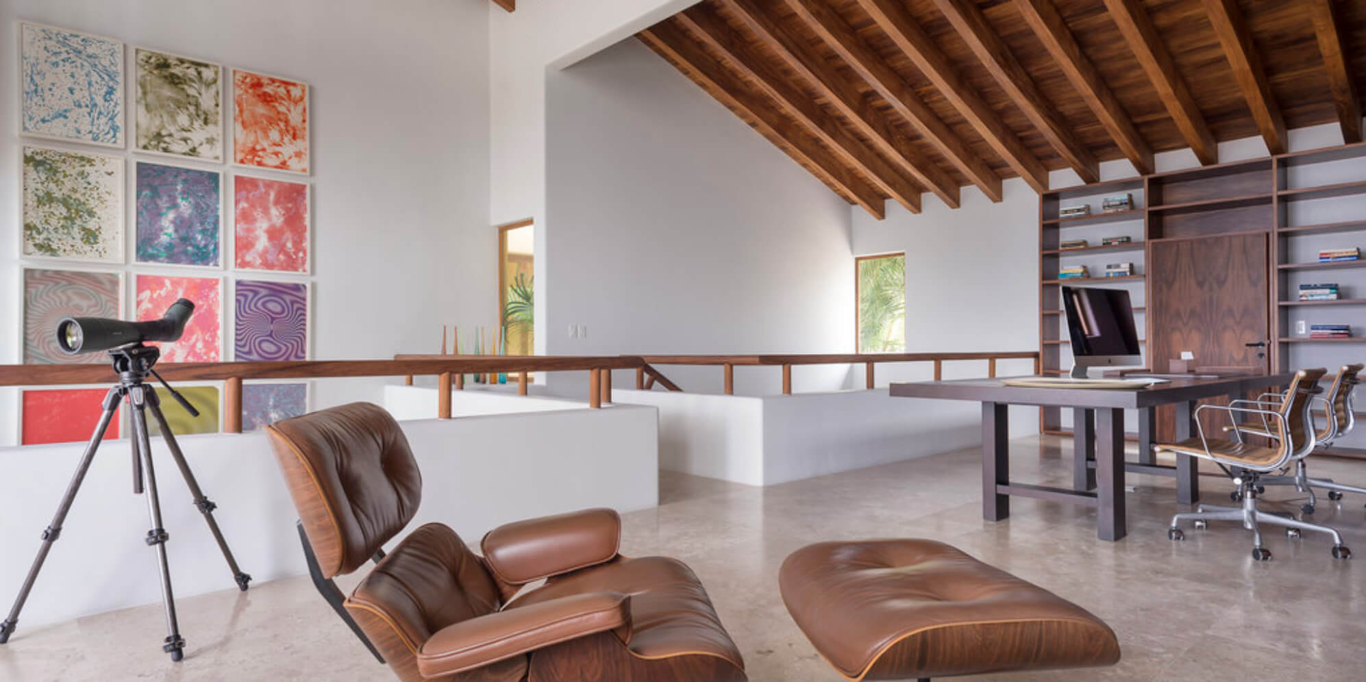 Upper-level study with Eames lounge chair and ottoman, walnut desk, iMac, spotting scope on tripod, and nine-panel abstract artwork on white wall, Estate Jaguar, Ranchos Estates, Punta Mita.