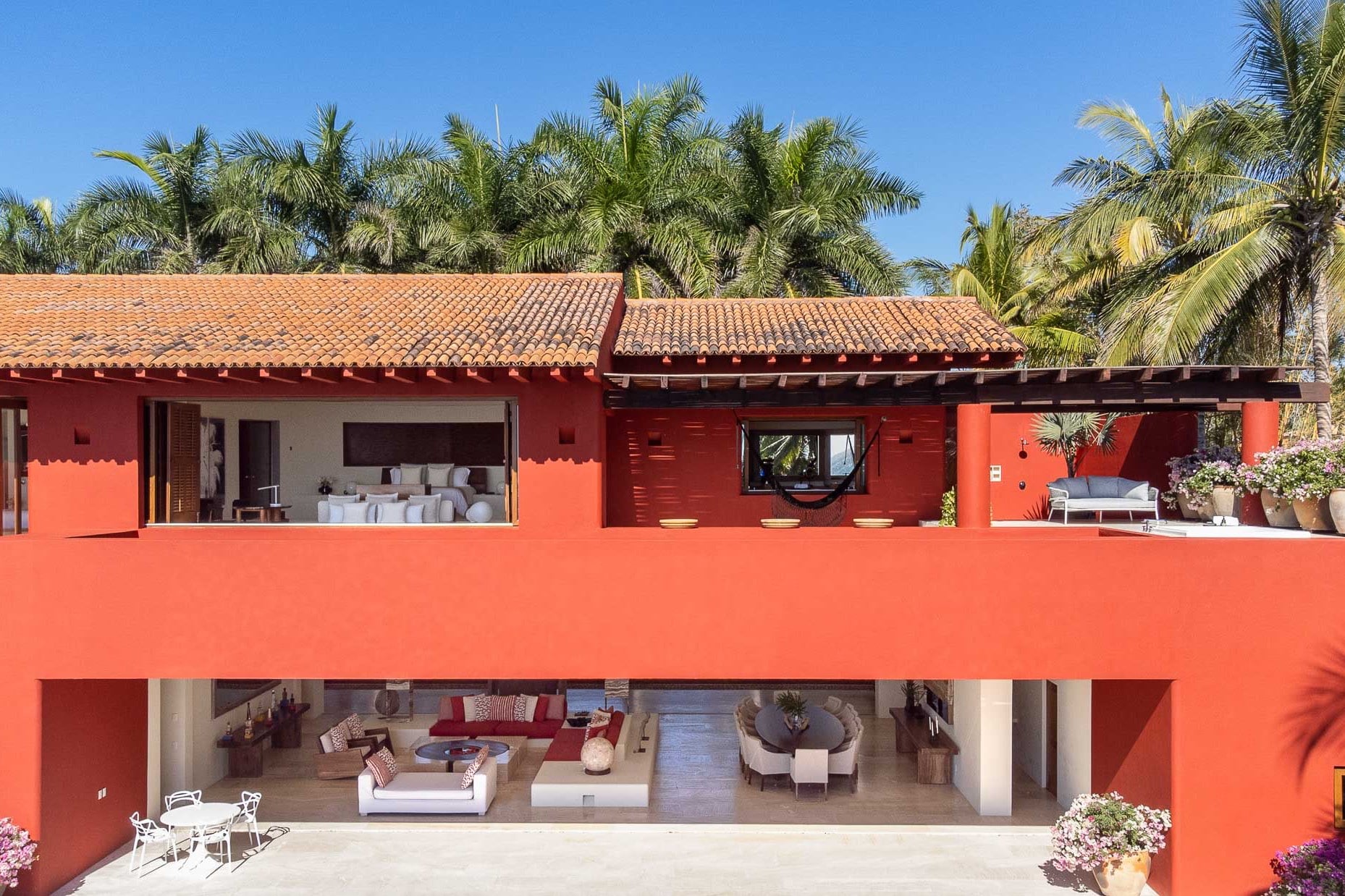 Villa facade from the garden showing open-air living pavilion, terracotta roof tiles, and bougainvillea planters, Villa Pacífica, Ranchos Estates, Punta Mita.