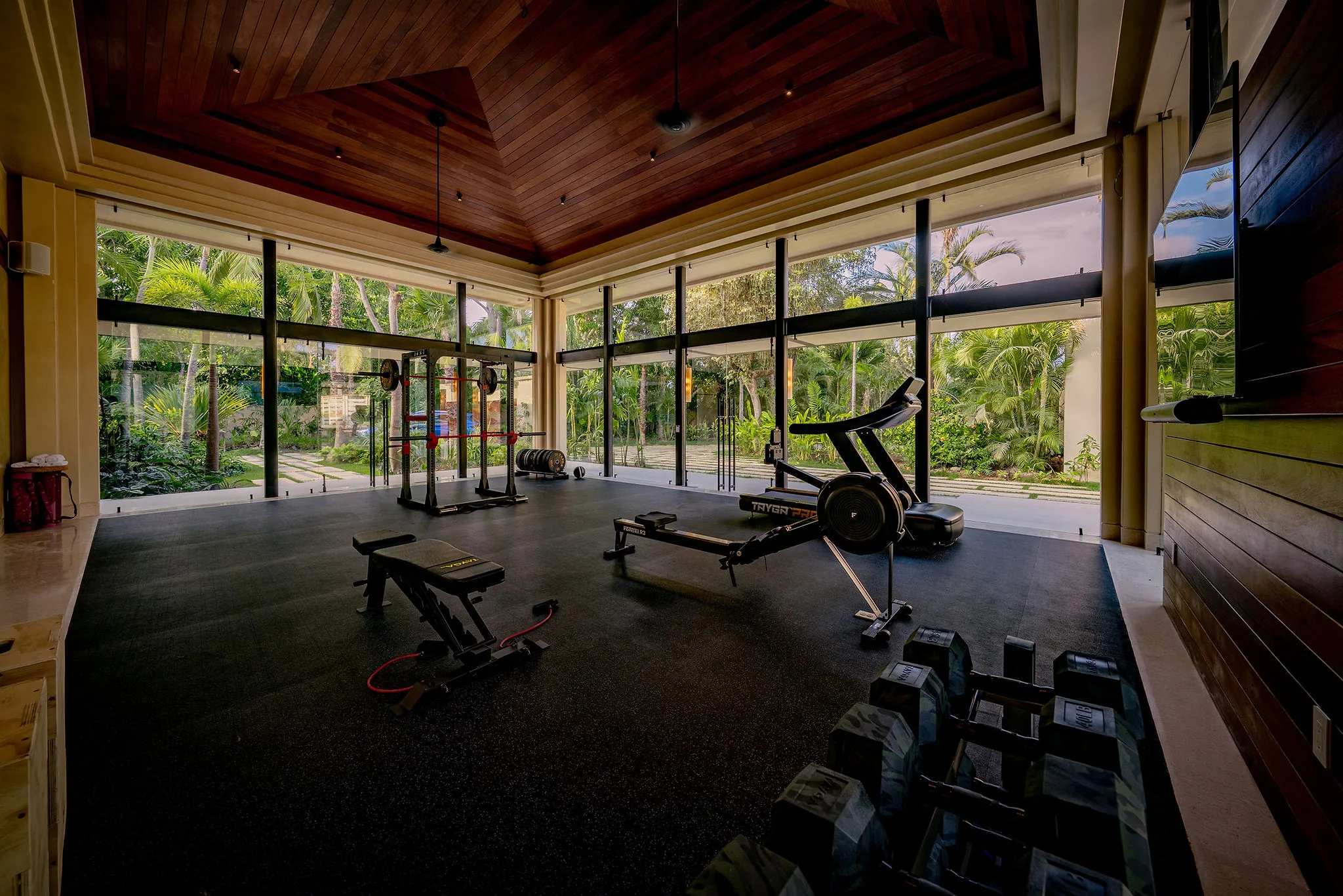 Modern gym at Casa Happy Paws in Punta Mita’s Ranchos Estates, with large windows, lush views, and full workout equipment.
