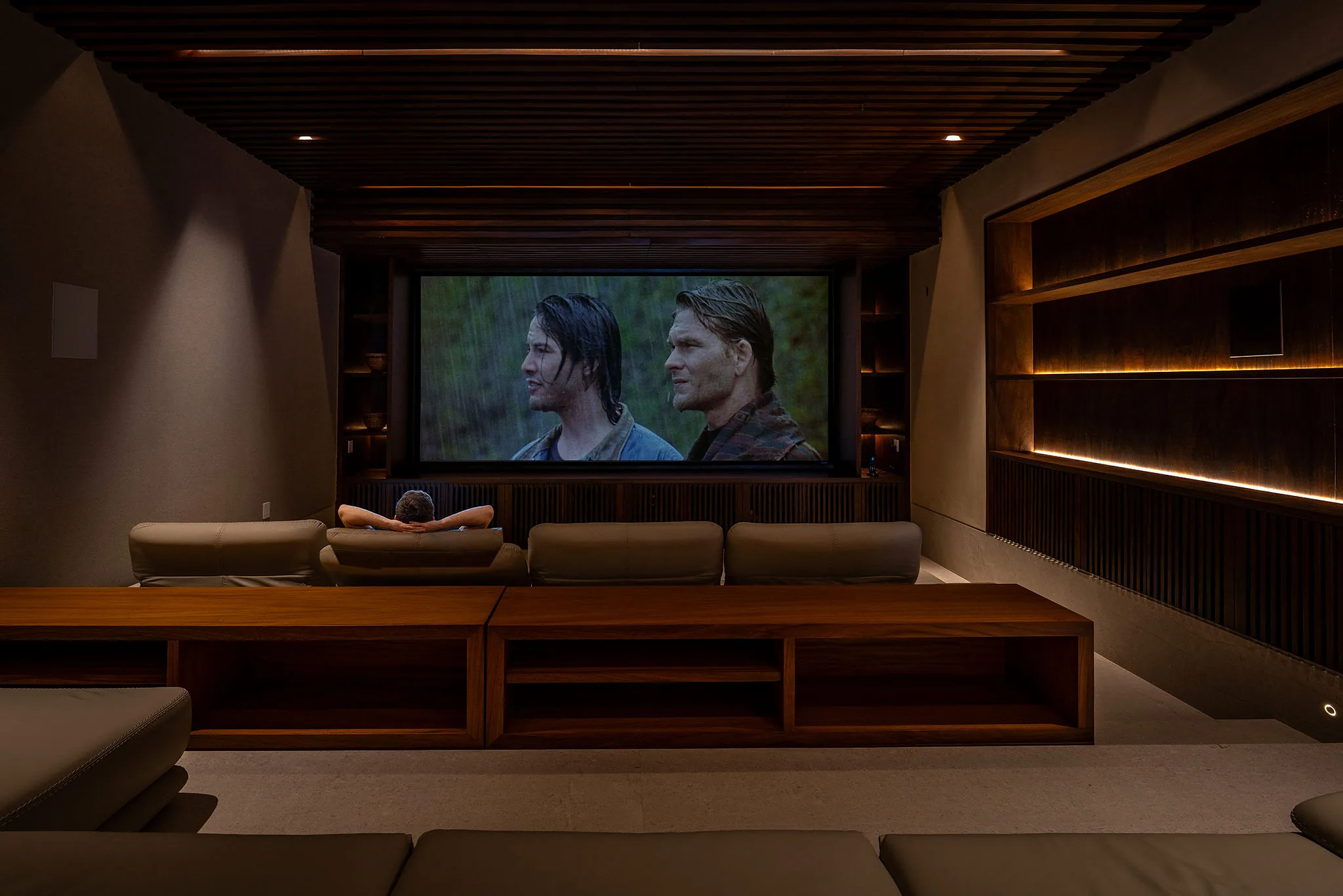 Modern, dimly lit home theater at Casa Happy Paws, Punta Mita, with cozy wood accents and luxury seating.