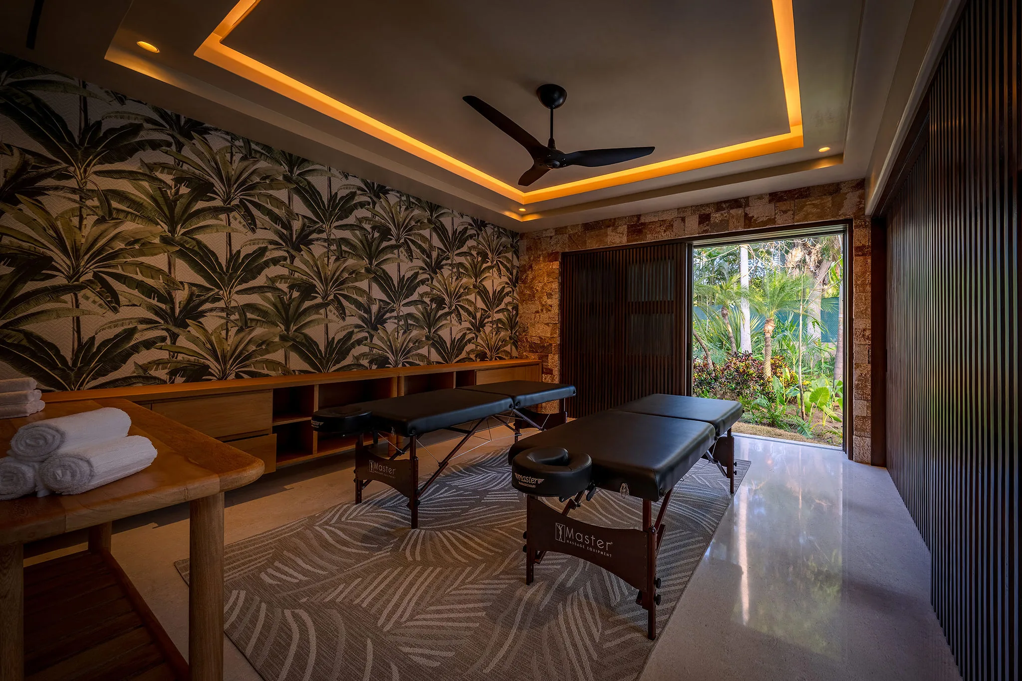 Spa room at Casa Happy Paws, Ranchos Estates, Punta Mita: two massage tables, tropical decor, garden views, soft lighting.