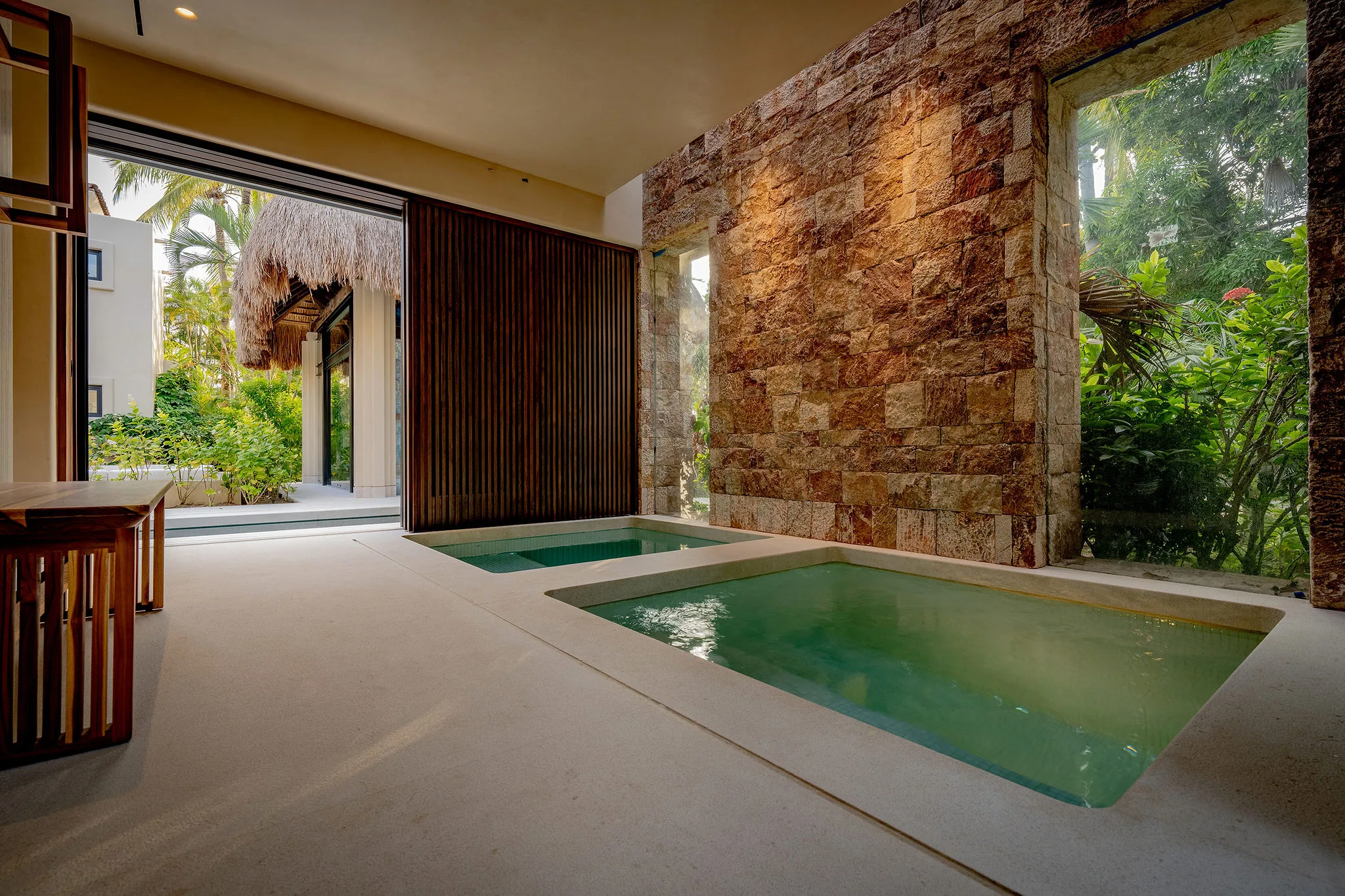 Modern spa at Casa Happy Paws, Punta Mita: two plunge pools, stone walls, garden views in Ranchos Estates, Mexico.