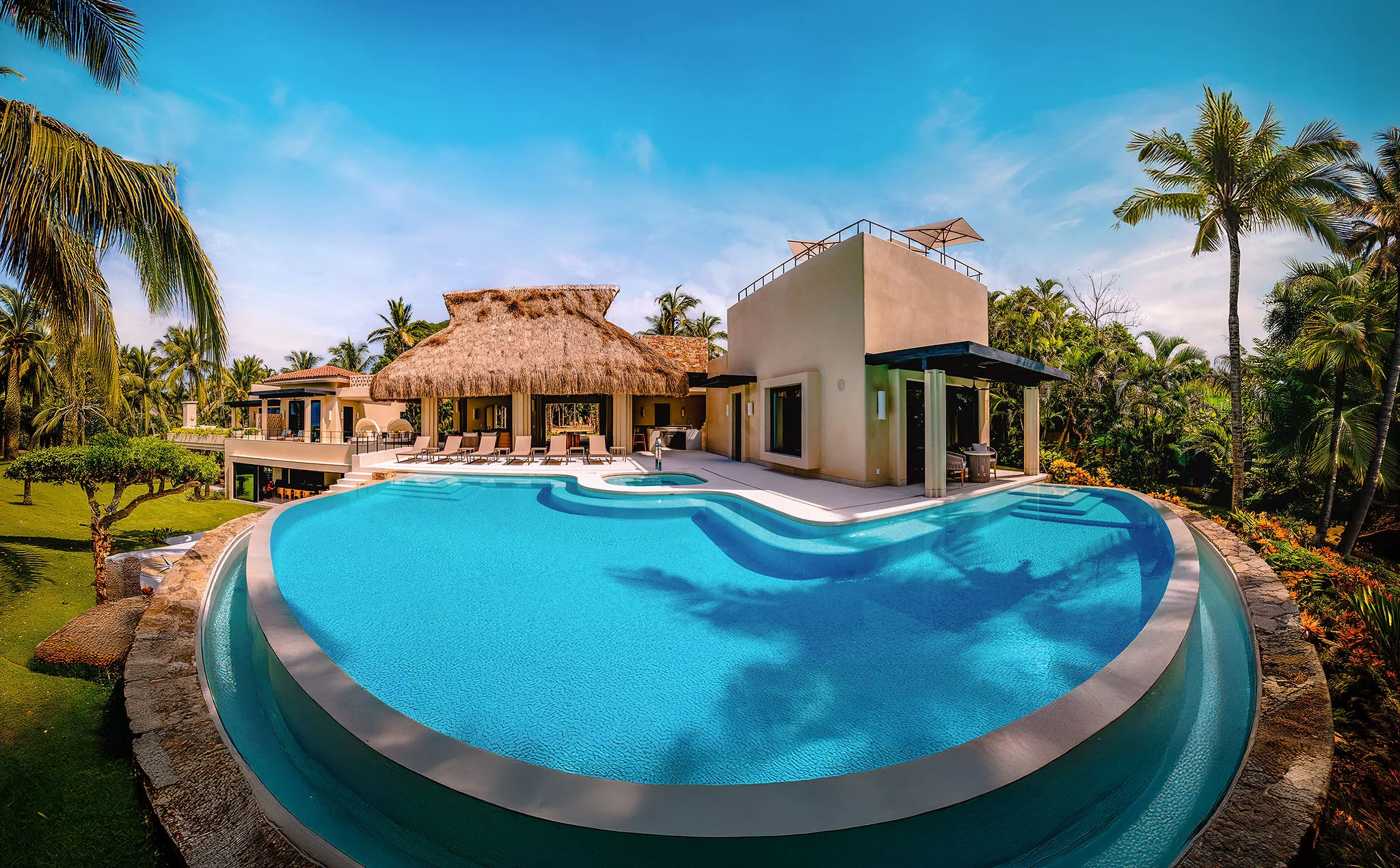 Casa Happy Paws, a modern villa in Punta Mita’s Ranchos Estates, boasts a curved infinity pool and tropical landscaping.