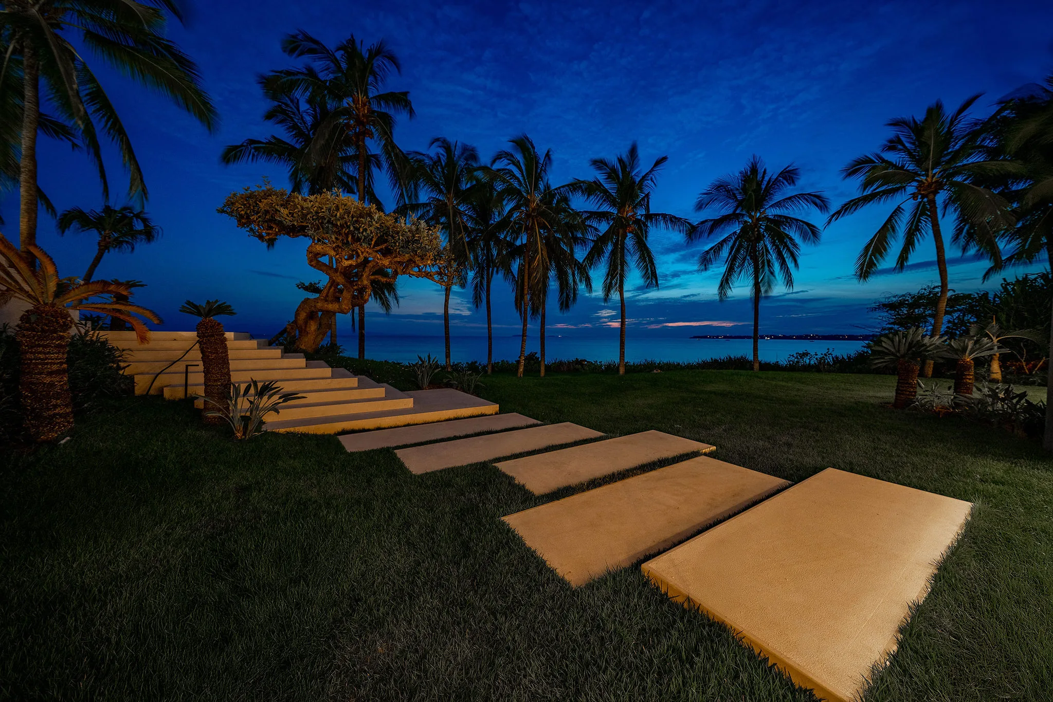Softly lit stone steps and palms at night by Casa Happy Paws, Ranchos Estates, Punta Mita, peaceful waterfront setting.