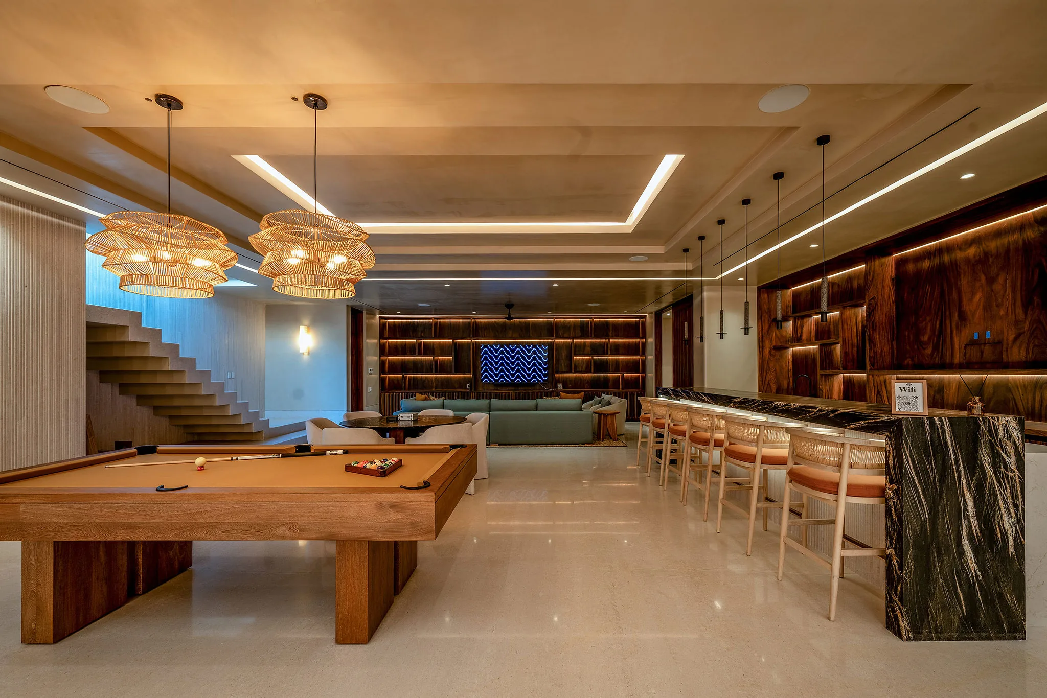 Modern game room at Casa Happy Paws, Ranchos Estates, Punta Mita with pool table, bar, TV, stylish lights, and soft-lit stairs.