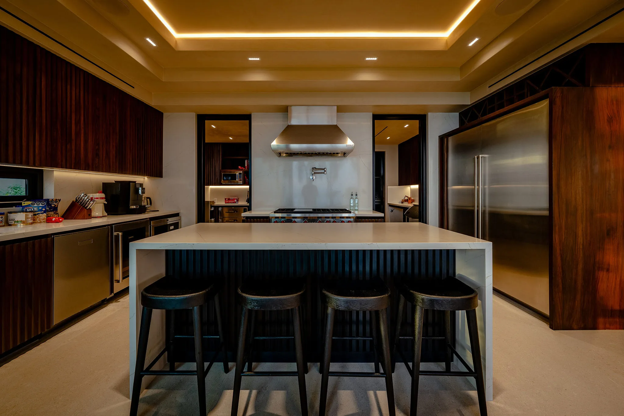 Contemporary kitchen at Casa Happy Paws, Punta Mita: dark wood cabinets, stainless appliances, sleek island, inviting lighting.