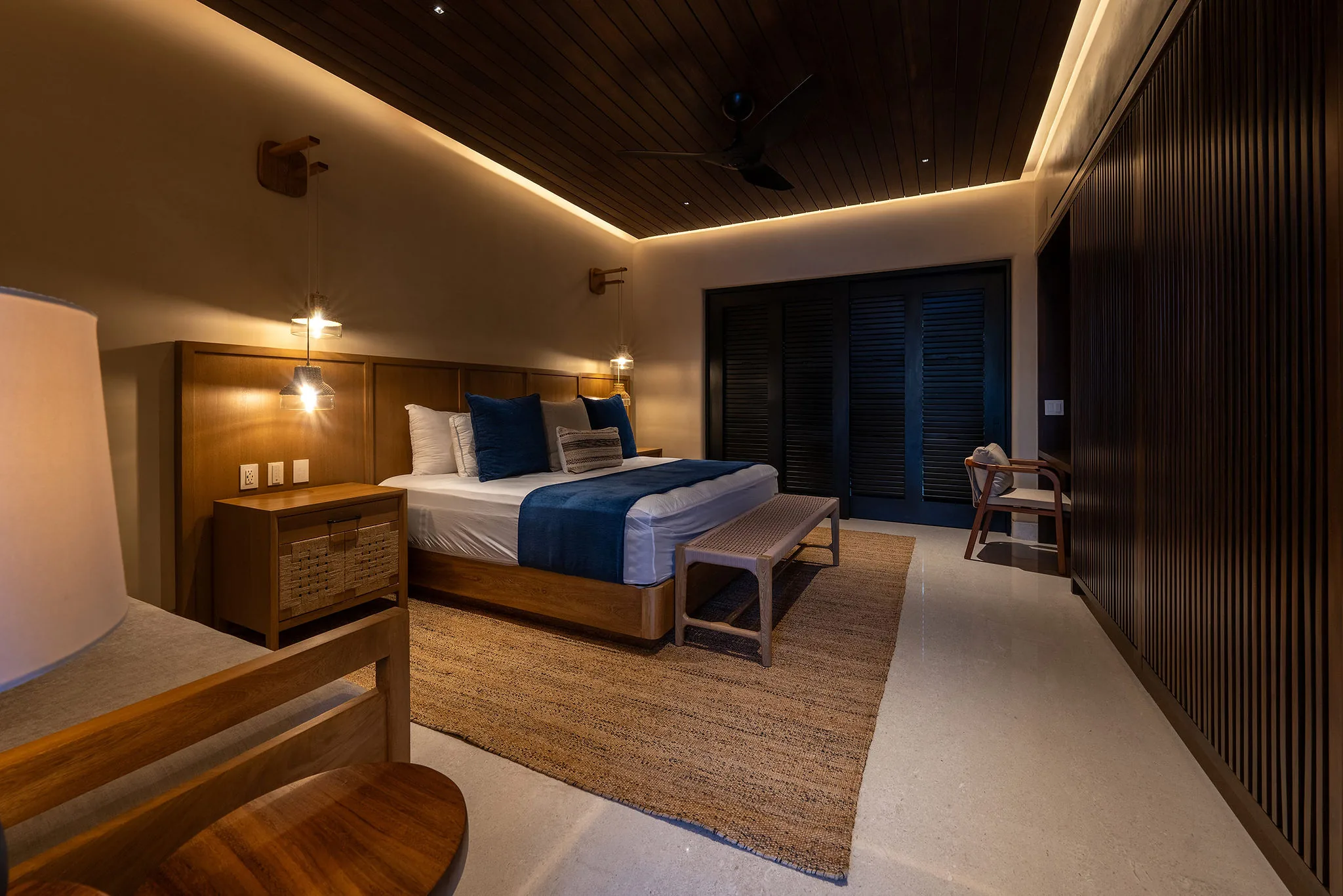 Chic Casa Happy Paws room in Punta Mita, Ranchos Estates: double bed, blue bedding, wood decor, warm lighting.