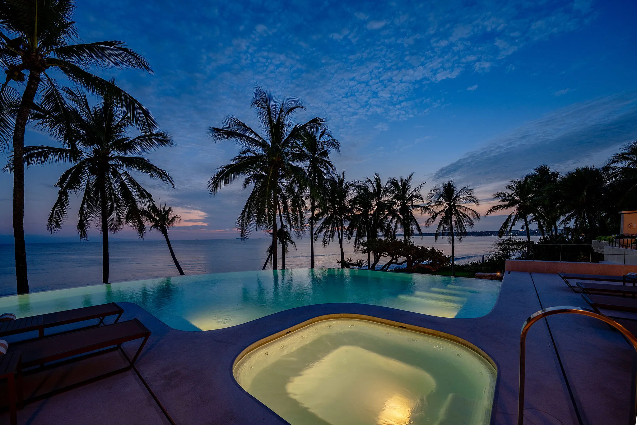 Infinity pool and hot tub at Casa Happy Paws, Ranchos Estates, Punta Mita, overlook sunset ocean and palm trees.