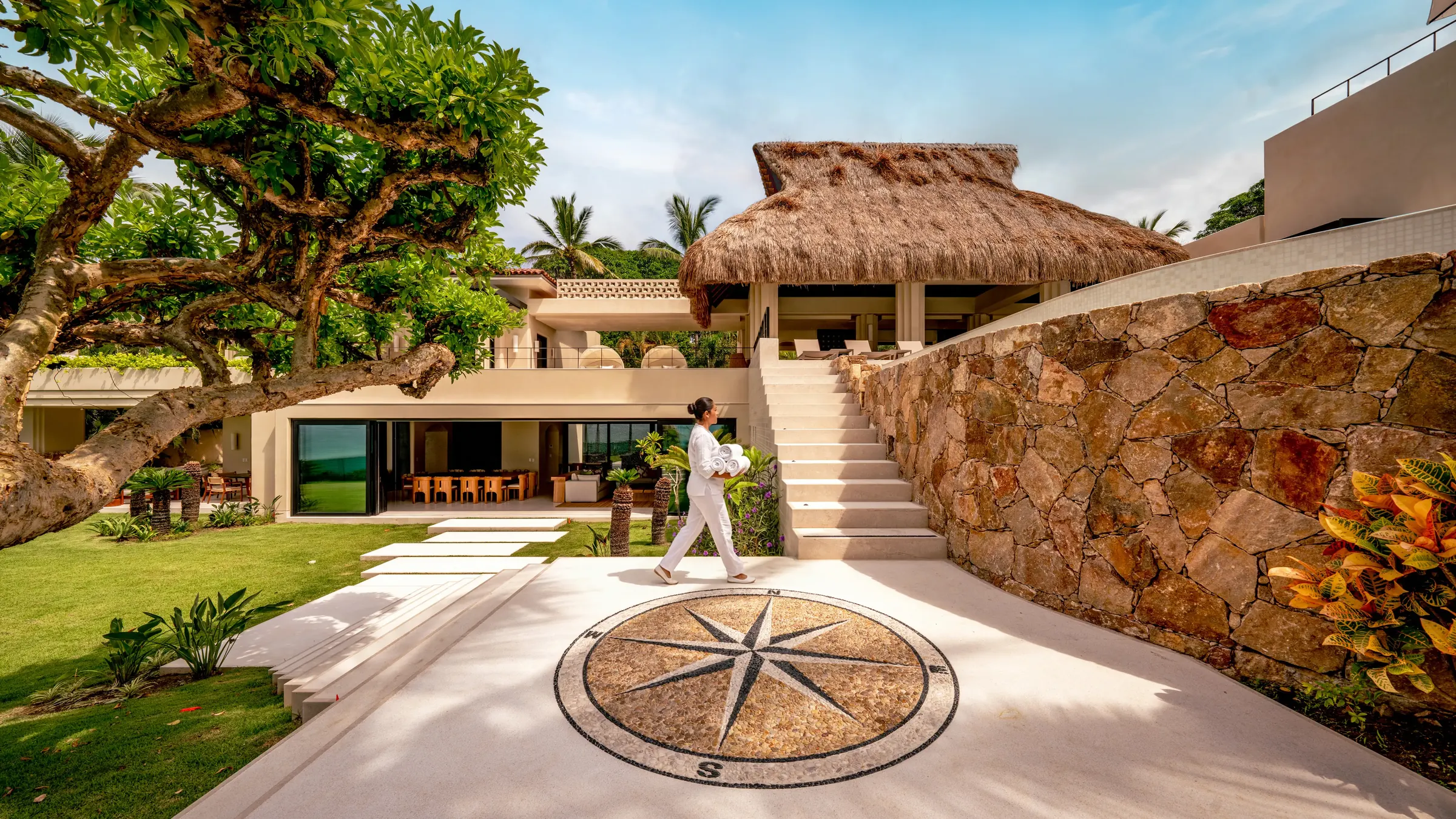 At Casa Happy Paws in Punta Mita’s Ranchos Estates, a person crosses a compass patio at this lush, luxury villa.