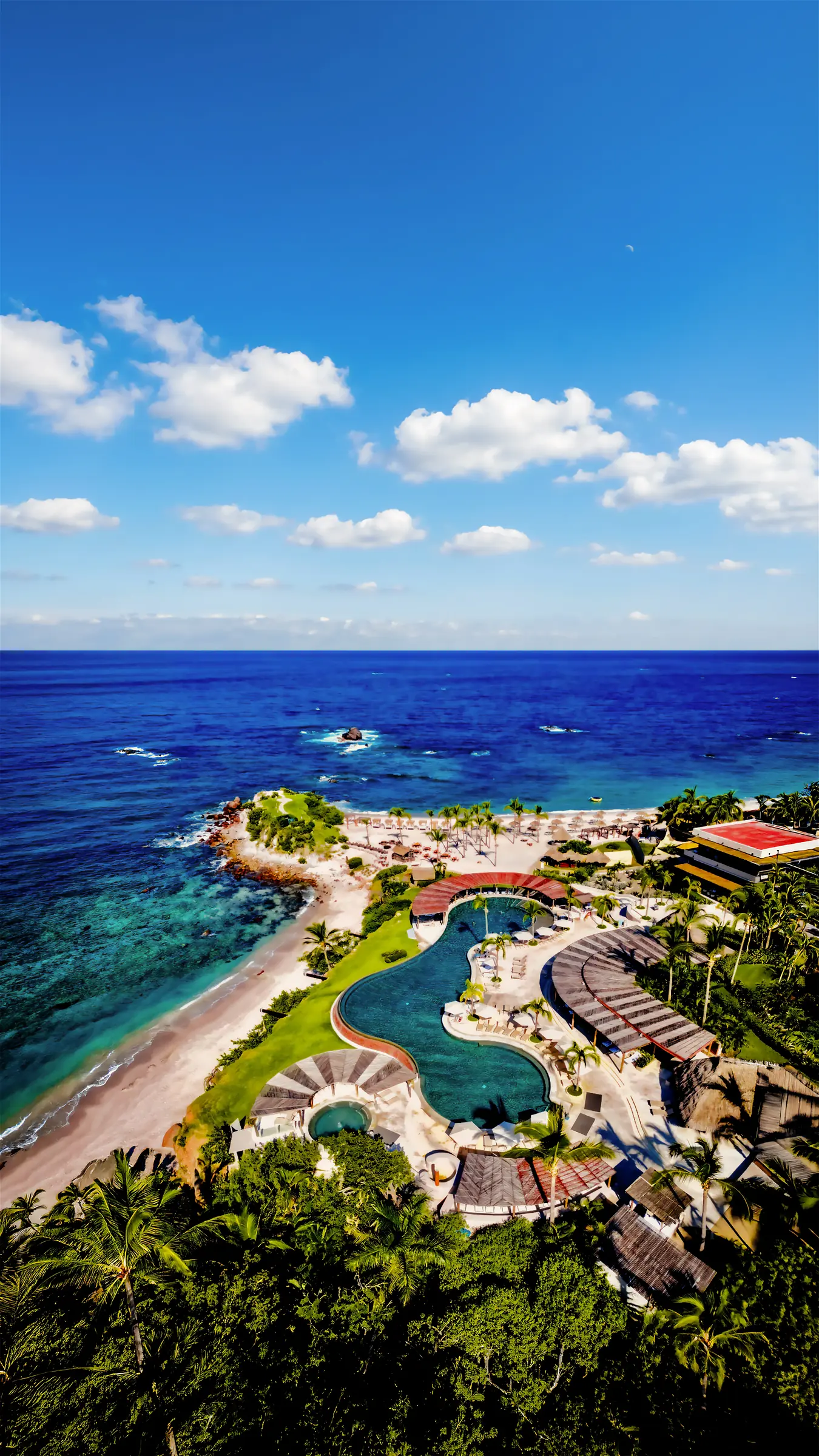 Aerial view of Casa Happy Paws at Ranchos Estates, Punta Mita, with pools, palms, lounge areas by beach and blue ocean.