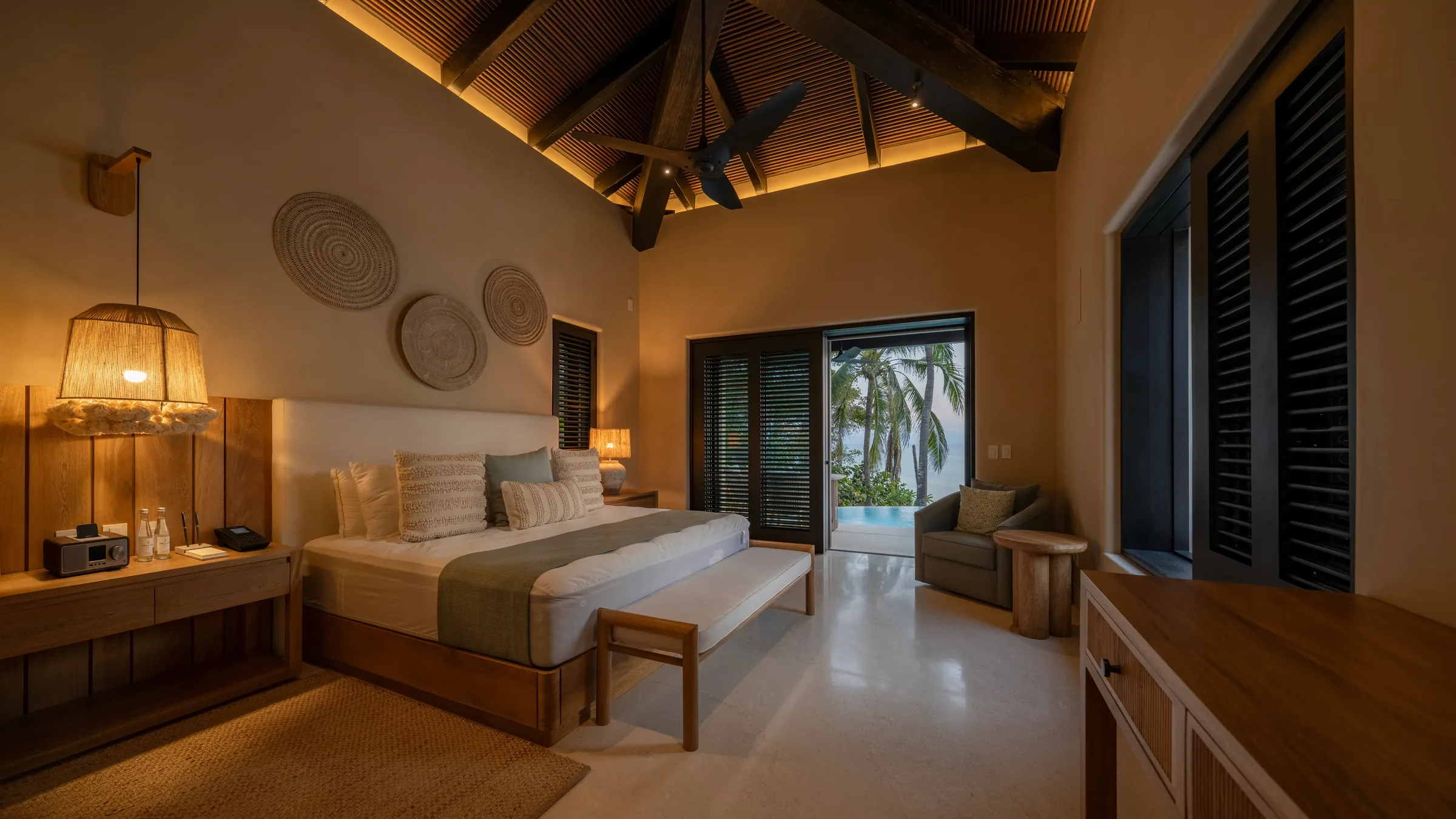 Modern, cozy Casa Happy Paws room in Punta Mita, Ranchos Estates with pool view, wood furniture, neutral tones, and palm trees.
