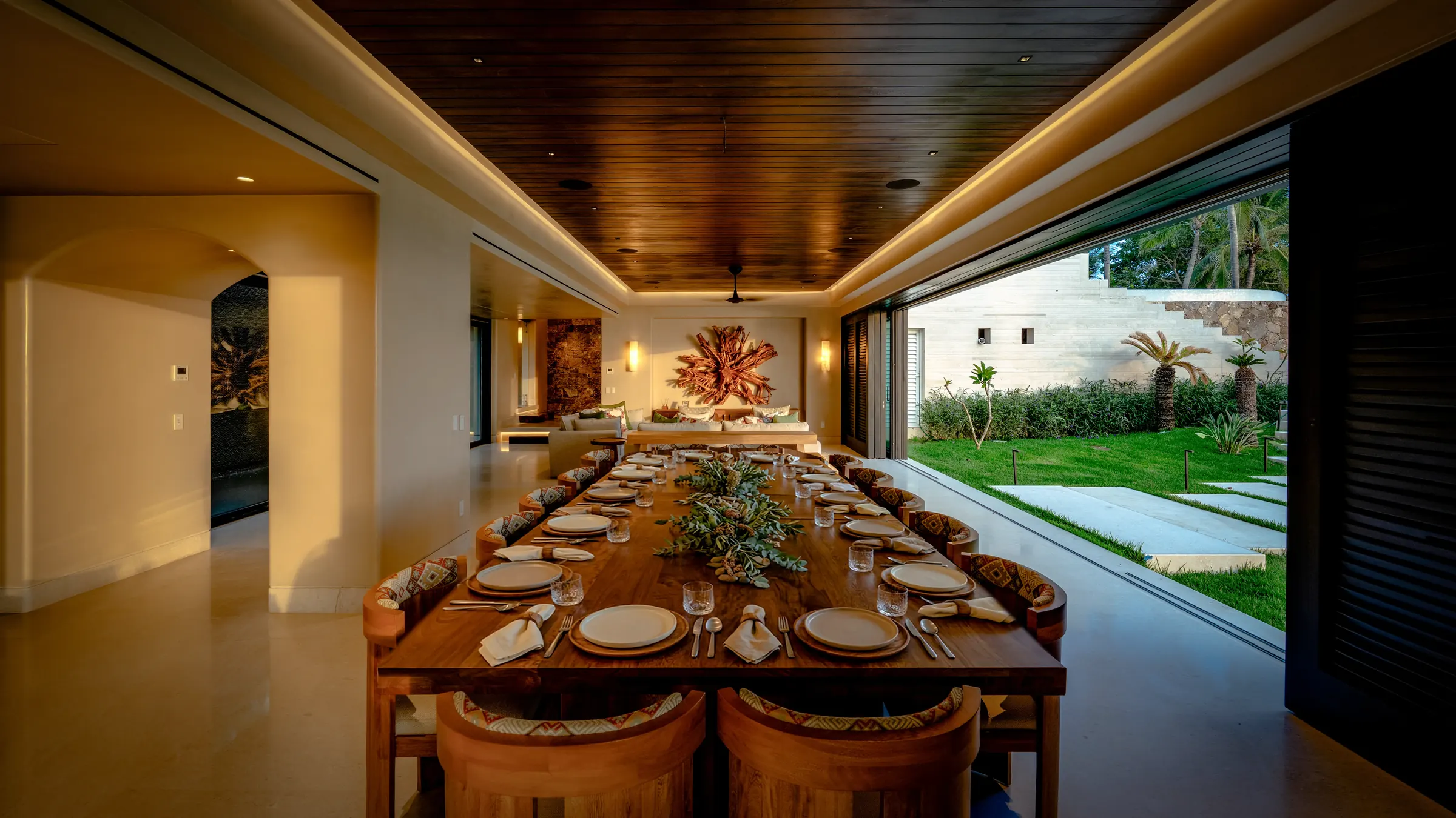 Elegant dining room at Casa Happy Paws, Punta Mita, with modern decor, garden view, and a long table set for dining.